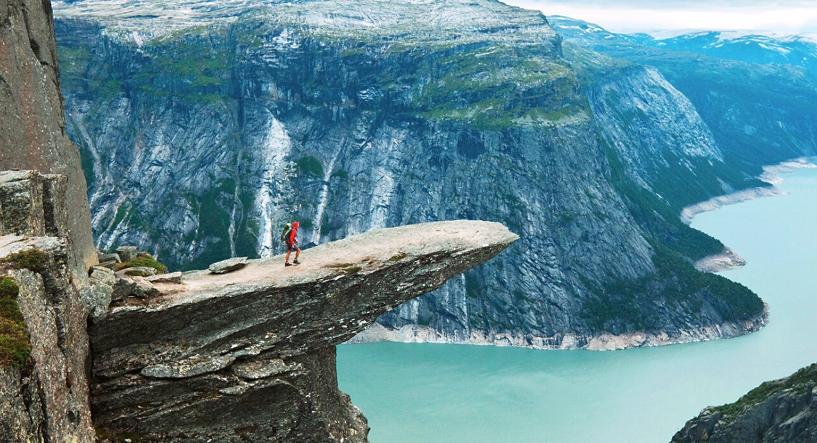 Bergsteiger wandert auf eine hohe Klippe
