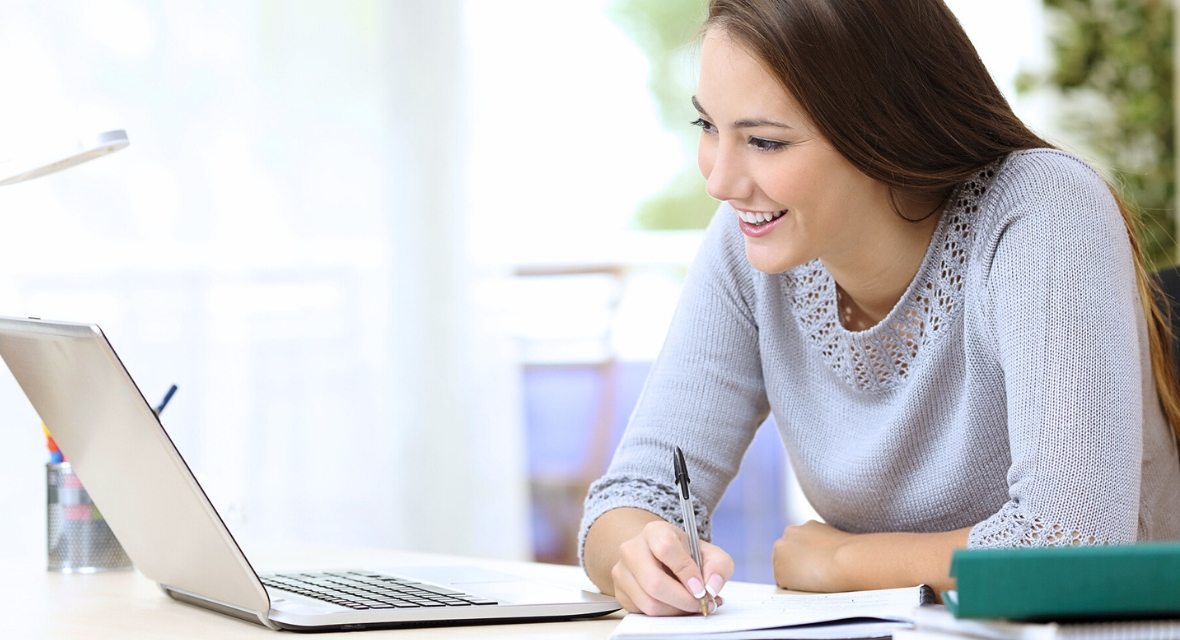 Junge Frau hört am Laptop erfreut zu